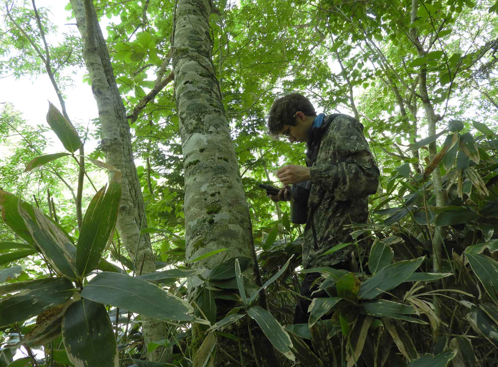 Юный волонтер Владимир Дормидонтов работает с фотоловушкой в Курильском заповеднике 